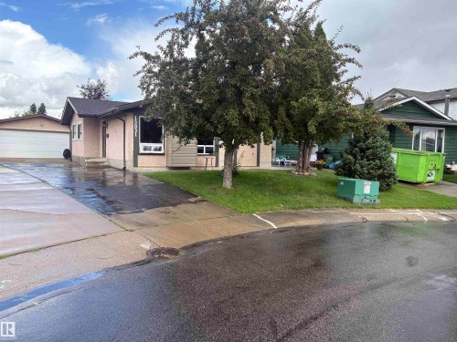 Single-story residence with a paved driveway, attached garage, and a landscaped front yard featuring mature trees - 13831 23 Street Nw, Edmonton, AB - Outdoor