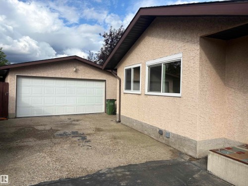 Detached garage with a paneled door, stucco exterior, and sloped roofline - 13831 23 Street Nw, Edmonton, AB - Outdoor With Exterior