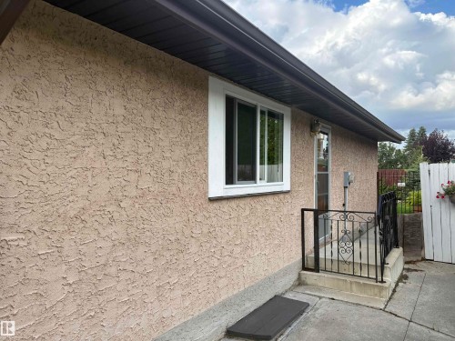 Stucco exterior with a white-framed sliding window - 13831 23 Street Nw, Edmonton, AB - Outdoor