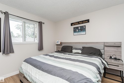 Wood-finish flooring with white baseboards and light-colored walls - 4521 29 Avenue Nw, Edmonton, AB - Indoor Photo Showing Bedroom