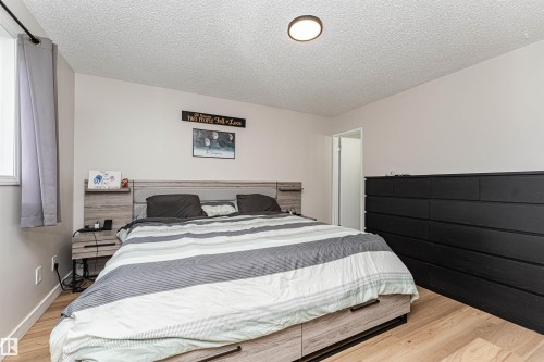 Wood-finish flooring, recessed ceiling lighting, light gray wall paint, and a window with white trim - 4521 29 Avenue Nw, Edmonton, AB - Indoor Photo Showing Bedroom