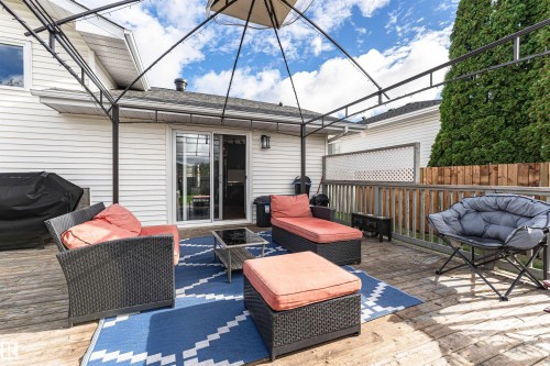 Expansive outdoor deck with wood-finish planks, featuring a sliding glass door, white horizontal siding, and a privacy fence - 4521 29 Avenue Nw, Edmonton, AB - Outdoor With Deck Patio Veranda With Exterior