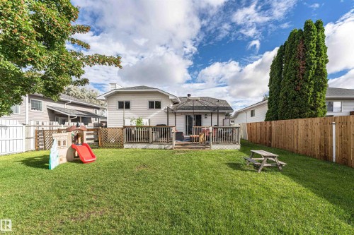 Expansive grassy yard with a wood fence and a raised wood deck - 4521 29 Avenue Nw, Edmonton, AB - Outdoor