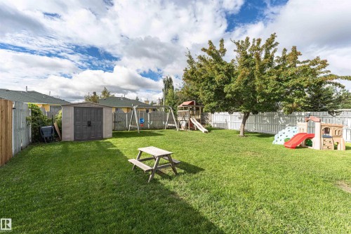 Expansive backyard featuring a manicured lawn, established trees, and a storage shed - 4521 29 Avenue Nw, Edmonton, AB - Outdoor