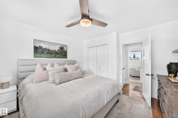 Recessed lighting, wood-finish flooring, white paneled doors, and a ceiling fan with integrated lighting - 