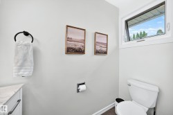 White-framed casement window, wall-mounted towel ring, built-in toilet paper holder, white toilet - 