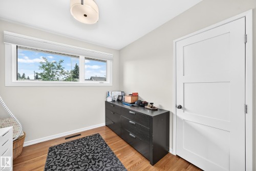 Wood-finish flooring, white paneled door, flush-mount ceiling light, and a horizontal window with white trim - 16406 87A Avenue Nw, Edmonton, AB - Indoor