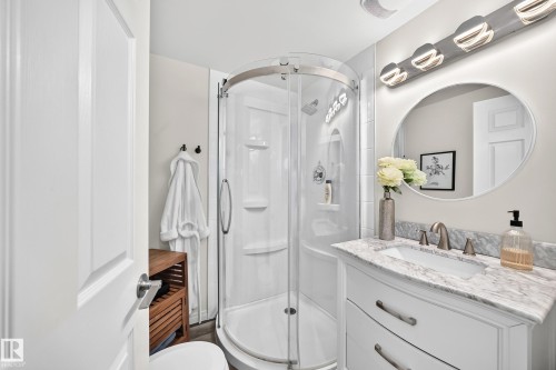 White shaker vanity with a stone countertop, undermount sink, and brushed nickel faucet - 16406 87A Avenue Nw, Edmonton, AB - Indoor Photo Showing Bathroom