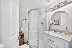 White shaker vanity with a stone countertop, undermount sink, and brushed nickel faucet - 