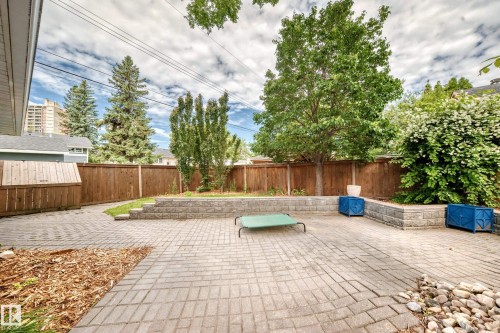 Paved patio area featuring brick-patterned pavers and a wood privacy fence - 16406 87A Avenue Nw, Edmonton, AB - Outdoor With Deck Patio Veranda