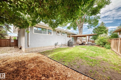 Expansive backyard featuring a covered patio, established trees, and a wooden fence - 16406 87A Avenue Nw, Edmonton, AB - Outdoor