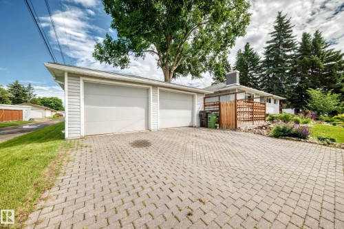 Two-car detached garage with panel doors, leading to a paver driveway - 16406 87A Avenue Nw, Edmonton, AB - Outdoor