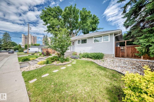 Siding exterior, multiple windows, stone landscaping, mature trees, and a wooden fence - 16406 87A Avenue Nw, Edmonton, AB - Outdoor
