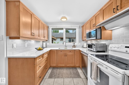 U-shaped kitchen featuring light wood cabinetry, white countertops, and a subway tile backsplash - 16406 87A Avenue Nw, Edmonton, AB - Indoor Photo Showing Kitchen