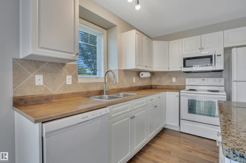 #1 5101 Soleil Bv, Beaumont, AB - Indoor Photo Showing Kitchen With Double Sink