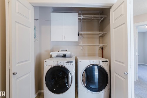 Laundry closet featuring white panel doors, wall-mounted cabinetry, and wire shelving - 5887 Sutter Place Nw, Edmonton, AB - Indoor Photo Showing Laundry Room