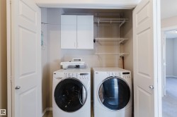 Laundry closet featuring white panel doors, wall-mounted cabinetry, and wire shelving - 