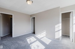 Neutral-toned walls, gray carpeting, a flush-mount ceiling light fixture, and white interior doors - 