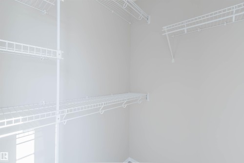 Built-in wire shelving system, multiple hanging rods, and light-toned wall paint - 5887 Sutter Place Nw, Edmonton, AB - Indoor With Storage