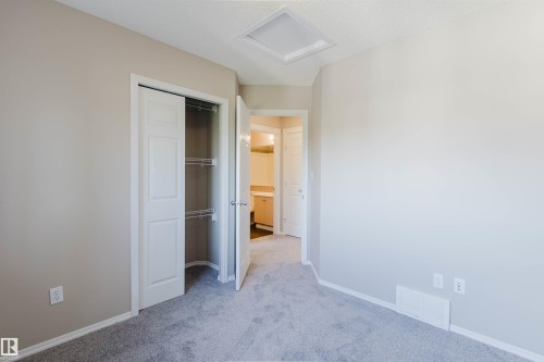 Neutral-toned walls complement the gray carpeting - 5887 Sutter Place Nw, Edmonton, AB - Indoor Photo Showing Other Room