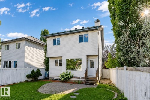 Expansive backyard featuring a manicured lawn, a paved patio, and a secure privacy fence - 5887 Sutter Place Nw, Edmonton, AB - Outdoor