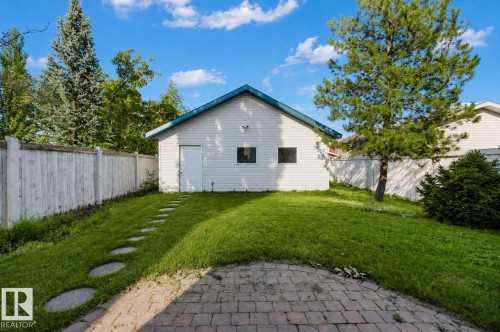 Detached accessory structure with siding exterior and a blue-pitched roof, featuring two windows and a side entry door - 5887 Sutter Place Nw, Edmonton, AB - Outdoor