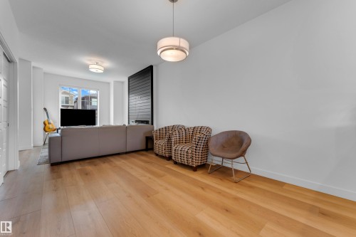 Hardwood flooring extending throughout, flush-mounted ceiling light fixture, and a large window - 3610 42 Avenue, Beaumont, AB - Indoor Photo Showing Living Room