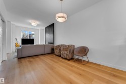 Hardwood flooring extending throughout, flush-mounted ceiling light fixture, and a large window - 
