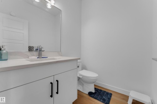 White vanity with black pulls, undermount sink, and light countertop - 3610 42 Avenue, Beaumont, AB - Indoor Photo Showing Bathroom