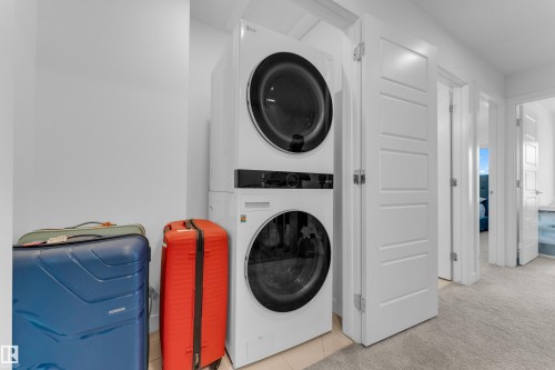 Stackable front-loading washer and dryer - 3610 42 Avenue, Beaumont, AB - Indoor Photo Showing Laundry Room