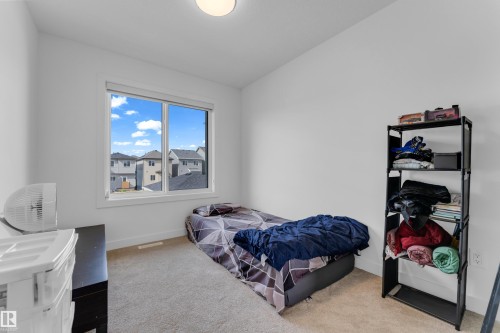 Bright room featuring a large window, neutral carpeting, and a flush-mount ceiling light - 3610 42 Avenue, Beaumont, AB - Indoor Photo Showing Bedroom