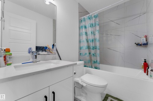 White vanity with integrated sink, contemporary faucet, and rectangular mirror - 3610 42 Avenue, Beaumont, AB - Indoor Photo Showing Bathroom