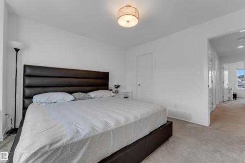 Plush carpet flooring, neutral wall tones, and a drum-shaped ceiling light fixture - 3610 42 Avenue, Beaumont, AB - Indoor Photo Showing Bedroom