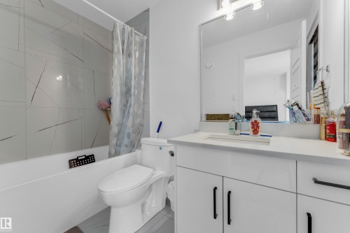 White vanity with integrated rectangular sink and a light-toned countertop - 3610 42 Avenue, Beaumont, AB - Indoor Photo Showing Bathroom
