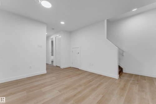 Spacious room featuring wood-finish flooring, recessed lighting, and a neutral color palette - 3610 42 Avenue, Beaumont, AB - Indoor Photo Showing Other Room