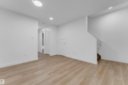 Spacious room featuring wood-finish flooring, recessed lighting, and a neutral color palette - 