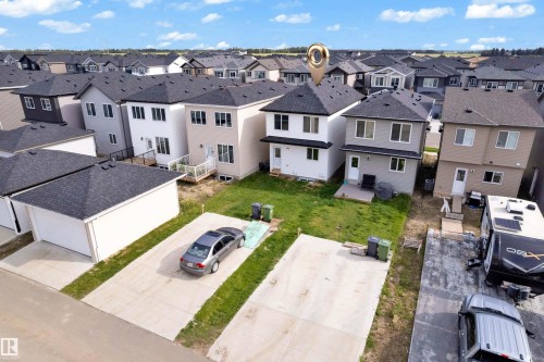 Concrete driveway with grass strips, detached garage, and a manicured lawn - 3610 42 Avenue, Beaumont, AB - Outdoor