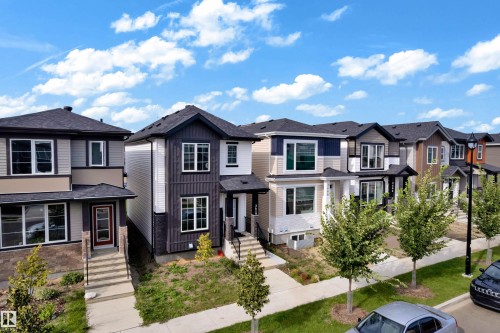 Modern exterior with contrasting siding, dark shingle roof, multiple windows, and a paved sidewalk - 3610 42 Avenue, Beaumont, AB - Outdoor With Facade