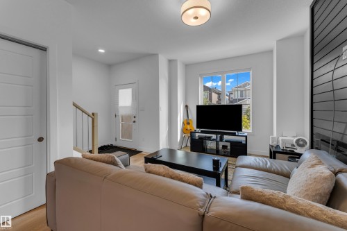 Recessed lighting and a flush mount fixture illuminate this space, featuring wood-finish flooring - 3610 42 Avenue, Beaumont, AB - Indoor Photo Showing Living Room