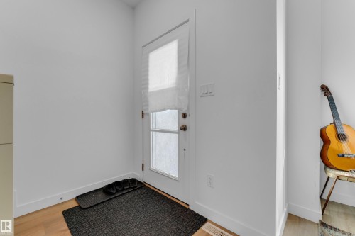 White paneled door with a privacy shade and light wood-finish flooring - 3610 42 Avenue, Beaumont, AB - Indoor Photo Showing Other Room