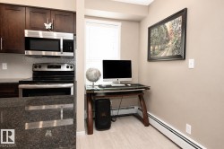 Dark wood cabinetry with stainless steel hardware, stainless steel microwave, stainless steel range, mosaic tile backsplash, and light wood-finish flooring - 