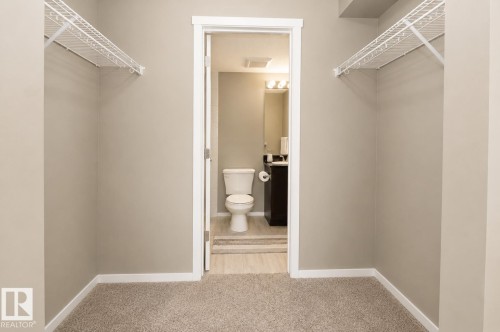 Carpeted area featuring wire shelving - #236 3315 James Mowatt Tr Sw, Edmonton, AB - Indoor