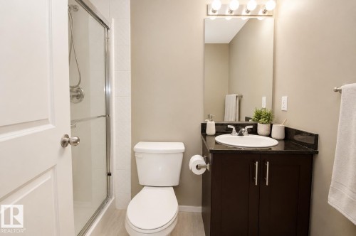Walk-in shower with clear glass enclosure and chrome fixtures - #236 3315 James Mowatt Tr Sw, Edmonton, AB - Indoor Photo Showing Bathroom