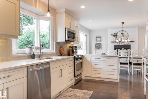 White cabinetry with stainless steel appliances, light-toned countertops, and a subway tile backsplash - 56 Highridge Way, Stony Plain, AB - Indoor Photo Showing Kitchen With Upgraded Kitchen