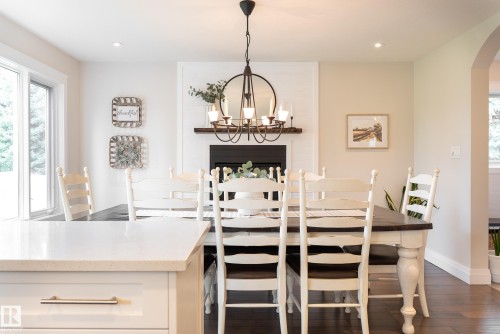 Built-in fireplace with a dark mantel, recessed lighting, wood-finish flooring, and a white countertop - 56 Highridge Way, Stony Plain, AB - Indoor Photo Showing Dining Room