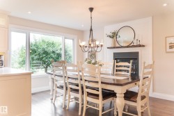 Built-in fireplace with a dark mantel, large multi-pane window, dark wood-finish flooring, and recessed lighting - 