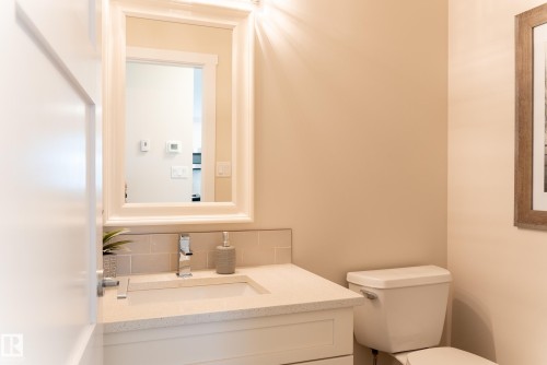 Vanity with integrated sink, polished chrome faucet, light-toned countertop, and subway tile backsplash - 56 Highridge Way, Stony Plain, AB - Indoor Photo Showing Bathroom
