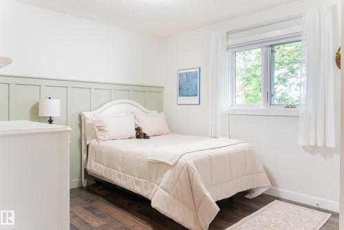 Wood-finish flooring, white walls, and a large window with white trim - 56 Highridge Way, Stony Plain, AB - Indoor Photo Showing Bedroom