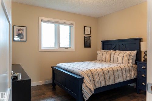 Wood-finish flooring with light-toned walls and crisp white trim - 56 Highridge Way, Stony Plain, AB - Indoor Photo Showing Bedroom
