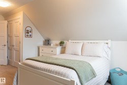 Sloped ceiling room featuring white panel doors, built-in closet, and light-colored carpeting - 